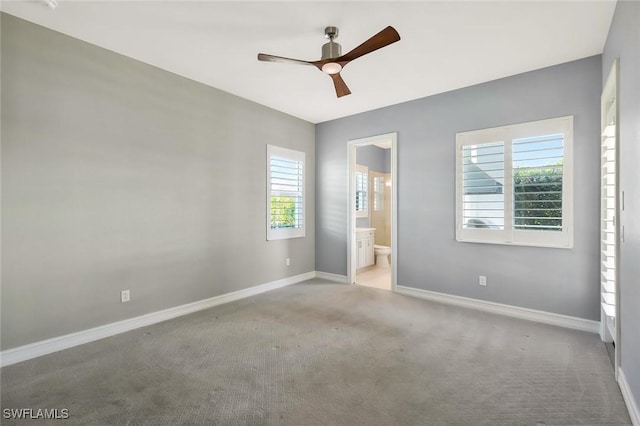 14792 Spinnaker Way, Naples, FL 34114 - unfurnished bedroom featuring multiple windows, carpet floors, ensuite bath, and a ceiling fan