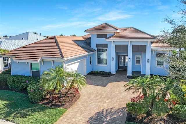 14792 Spinnaker Way, Naples, FL 34114 - view of front of property featuring a garage, a tile roof, stucco siding, and french doors