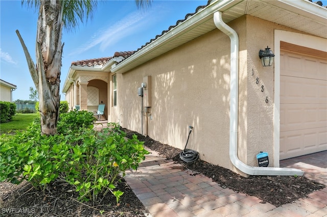1886 Alameda Dr, Naples, FL 34120 - view of side of property with stucco siding, a garage, and a tile roof