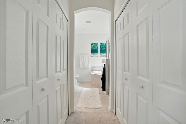1886 Alameda Dr, Naples, FL 34120 - hallway with arched walkways and light carpet