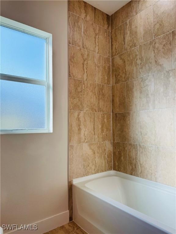 1062 Jay Ct, Labelle, FL 33935 - bathroom featuring baseboards and washtub / shower combination