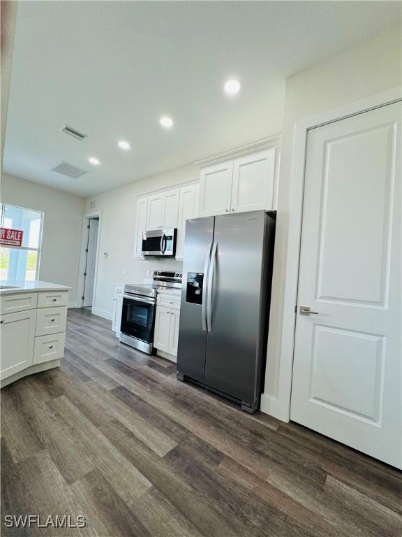 1062 Jay Ct, Labelle, FL 33935 - kitchen with appliances with stainless steel finishes, dark wood-type flooring, white cabinetry, and recessed lighting