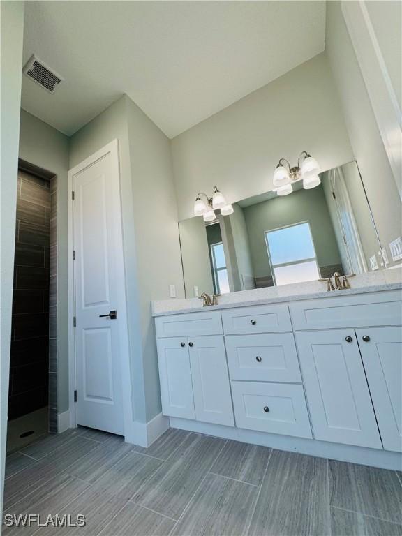 1062 Jay Ct, Labelle, FL 33935 - bathroom with double vanity, tiled shower, and wood finish floors