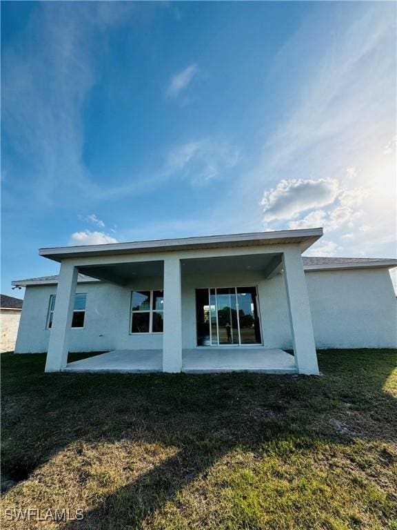 1062 Jay Ct, Labelle, FL 33935 - rear view of house with a patio area, stucco siding, and a lawn