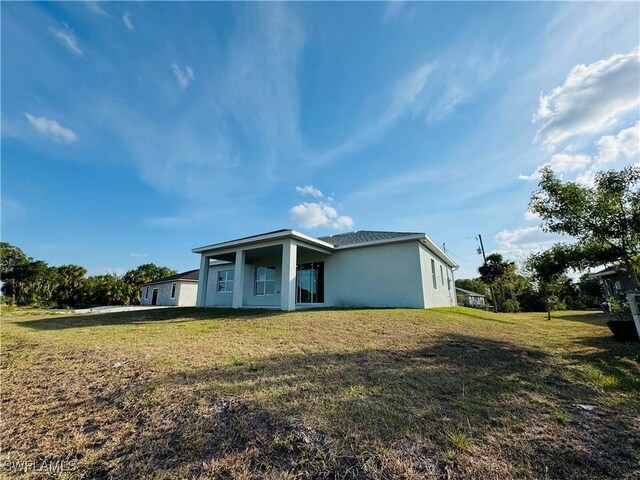 1062 Jay Ct, Labelle, FL 33935 - rear view of house featuring stucco siding and a yard