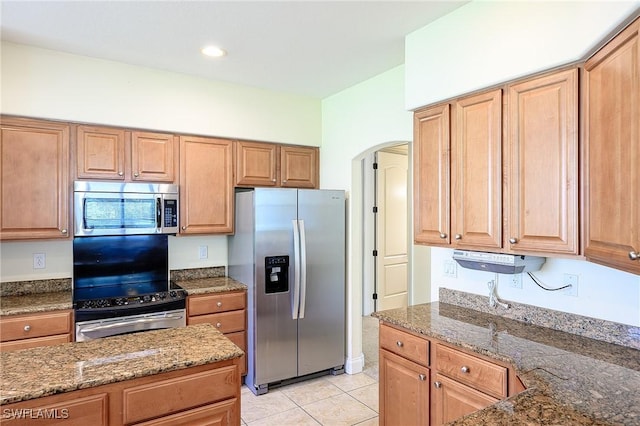 1314 Corso Palermo Ct Unit 1802, Naples, FL 34105 - kitchen featuring stainless steel appliances, arched walkways, dark stone counters, light tile patterned floors, and recessed lighting