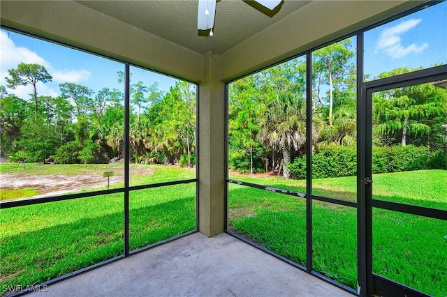 1314 Corso Palermo Ct Unit 1802, Naples, FL 34105 - unfurnished sunroom featuring a ceiling fan and view of wooded area
