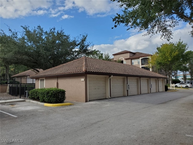 6141 Metrowest Blvd Unit 206, Orlando, FL 32835 - view of property exterior featuring community garages, a tile roof, and stucco siding