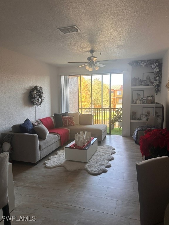 6141 Metrowest Blvd Unit 206, Orlando, FL 32835 - living area featuring plenty of natural light, a ceiling fan, and a textured ceiling