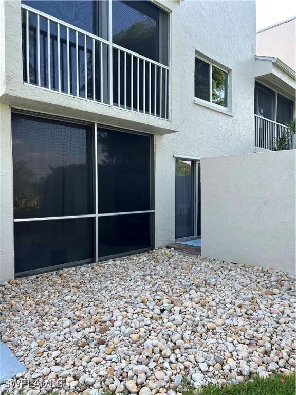 3062 Kings Lake Blvd Unit 7511, Naples, FL 34112 - doorway to property featuring stucco siding and a balcony