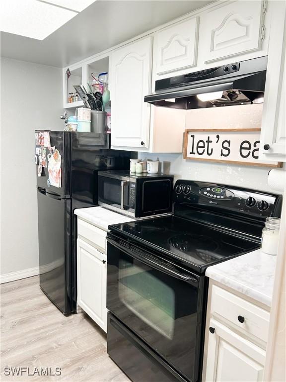 3062 Kings Lake Blvd Unit 7511, Naples, FL 34112 - kitchen featuring black appliances, under cabinet range hood, white cabinetry, and light wood finished floors