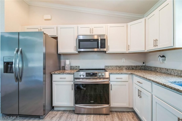 6009 S Moss Cir, Labelle, FL 33935 - kitchen with appliances with stainless steel finishes, vaulted ceiling, ornamental molding, light wood-style flooring, and light stone counters