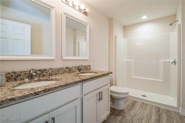 6009 S Moss Cir, Labelle, FL 33935 - bathroom featuring wood finished floors, double vanity, toilet, and a shower