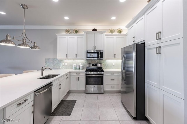 4330 Aurora St, Naples, FL 34119 - kitchen featuring stainless steel appliances, a sink, crown molding, a peninsula, and light countertops