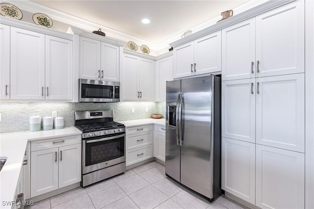 4330 Aurora St, Naples, FL 34119 - kitchen featuring stainless steel appliances, light tile patterned floors, light countertops, tasteful backsplash, and white cabinets