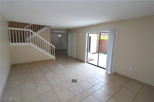 5216 Cedarbend Dr Unit 3, Fort Myers, FL 33919 - unfurnished room with stairs, light tile patterned floors, a textured ceiling, baseboards, and a chandelier