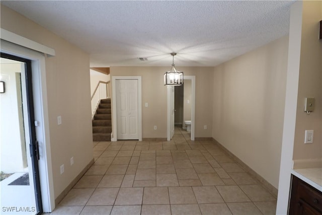 5216 Cedarbend Dr Unit 3, Fort Myers, FL 33919 - spare room featuring stairs, light tile patterned floors, a textured ceiling, and baseboards