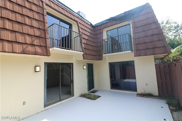 5216 Cedarbend Dr Unit 3, Fort Myers, FL 33919 - back of house with stucco siding, a patio area, and mansard roof
