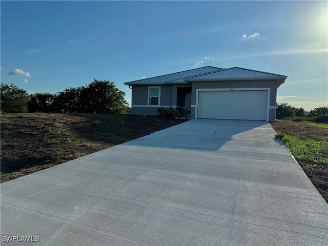 538 David Cir, Labelle, FL 33935 - view of front of home with concrete driveway, a garage, stucco siding, metal roof, and a standing seam roof