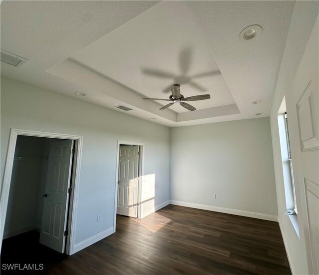 538 David Cir, Labelle, FL 33935 - unfurnished bedroom with a raised ceiling, dark wood-style flooring, baseboards, a spacious closet, and ceiling fan