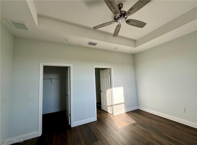 538 David Cir, Labelle, FL 33935 - unfurnished bedroom with wood finished floors, a raised ceiling, baseboards, a walk in closet, and a closet