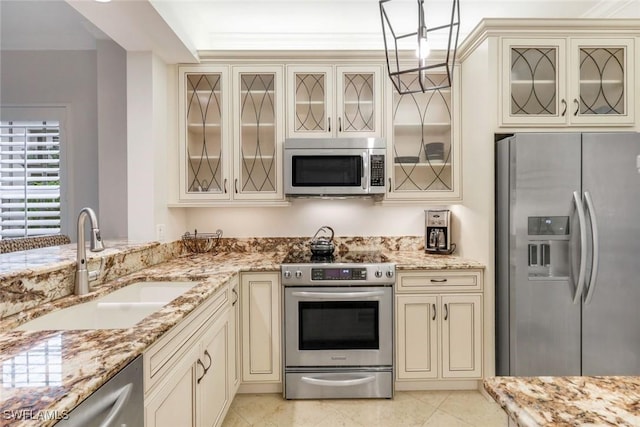 401 Bayfront Pl Unit 3301, Naples, FL 34102 - kitchen with cream cabinetry, stainless steel appliances, a sink, light stone countertops, and glass insert cabinets
