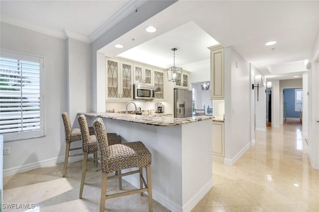 401 Bayfront Pl Unit 3301, Naples, FL 34102 - kitchen featuring appliances with stainless steel finishes, crown molding, light stone counters, a peninsula, and a kitchen breakfast bar