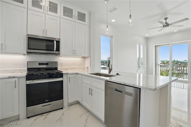 855 Lagoon St Unit 3, Fort Myers Beach, FL 33931 - kitchen featuring appliances with stainless steel finishes, a sink, a peninsula, plenty of natural light, and recessed lighting