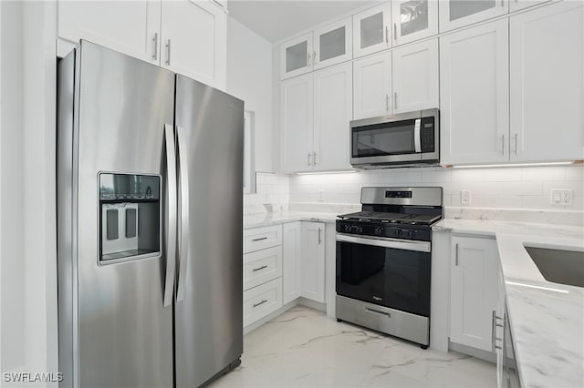 855 Lagoon St Unit 3, Fort Myers Beach, FL 33931 - kitchen featuring stainless steel appliances, white cabinets, light marble finish floors, and light stone countertops