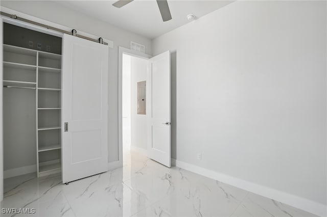 855 Lagoon St Unit 4, Fort Myers Beach, FL 33931 - unfurnished bedroom featuring baseboards, marble finish flooring, electric panel, and a barn door