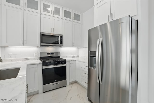 855 Lagoon St Unit 4, Fort Myers Beach, FL 33931 - kitchen featuring stainless steel appliances, a sink, light marble finish flooring, white cabinetry, and light stone counters