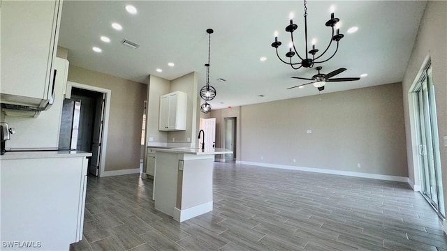 1115 Leader St, Labelle, FL 33935 - kitchen featuring light countertops, a ceiling fan, open floor plan, baseboards, and white cabinets