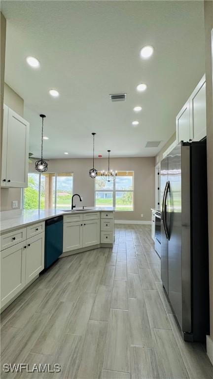1115 Leader St, Labelle, FL 33935 - kitchen featuring appliances with stainless steel finishes, a sink, recessed lighting, light wood finished floors, and a peninsula