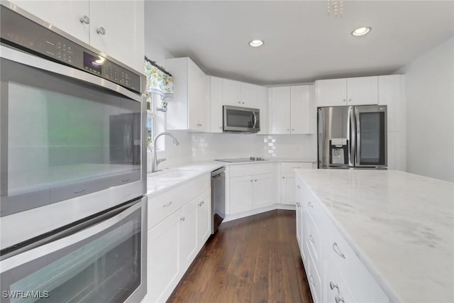 2940 14th Ave SE, Naples, FL 34117 - kitchen with appliances with stainless steel finishes, dark wood-style flooring, white cabinetry, light stone countertops, and recessed lighting