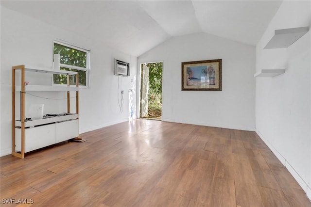 2940 14th Ave SE, Naples, FL 34117 - unfurnished living room featuring healthy amount of natural light, wood finished floors, lofted ceiling, and a wall unit AC