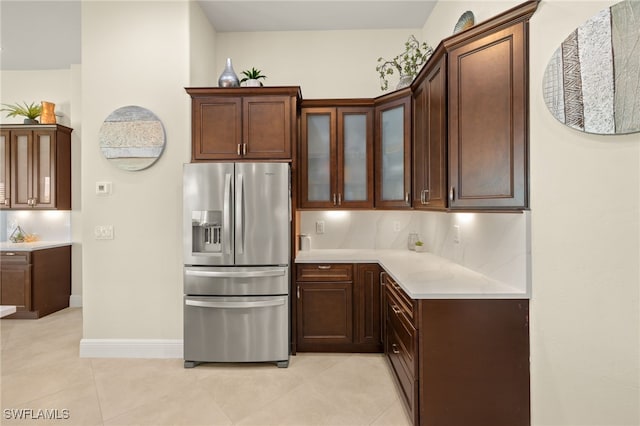 1206 SW 18th Ave, Cape Coral, FL 33991 - kitchen featuring stainless steel fridge, light countertops, glass insert cabinets, light tile patterned floors, and baseboards