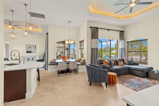 1206 SW 18th Ave, Cape Coral, FL 33991 - living room with a tray ceiling, a ceiling fan, light tile patterned floors, and a chandelier