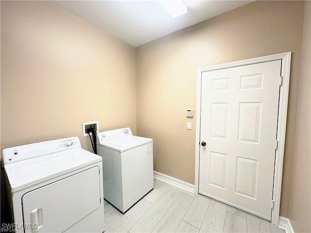 8088 Sanctuary Dr Unit 1, Naples, FL 34104 - laundry room with washer and dryer, baseboards, and light wood finished floors