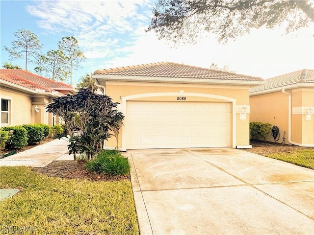 8088 Sanctuary Dr Unit 1, Naples, FL 34104 - mediterranean / spanish-style house featuring stucco siding, driveway, a tile roof, and an attached garage