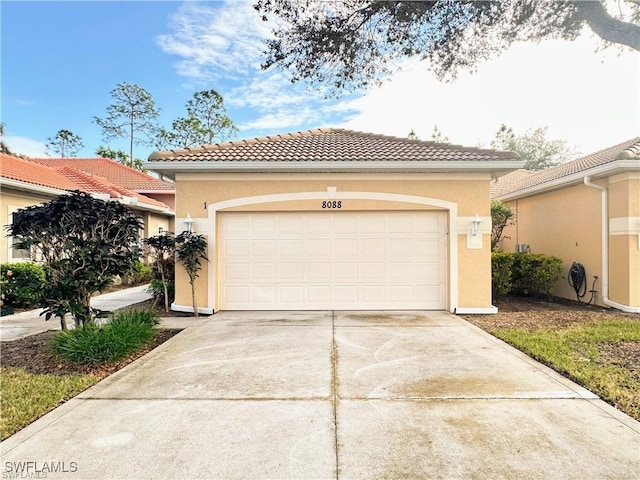 8088 Sanctuary Dr Unit 1, Naples, FL 34104 - mediterranean / spanish home featuring driveway, stucco siding, a tiled roof, and a garage
