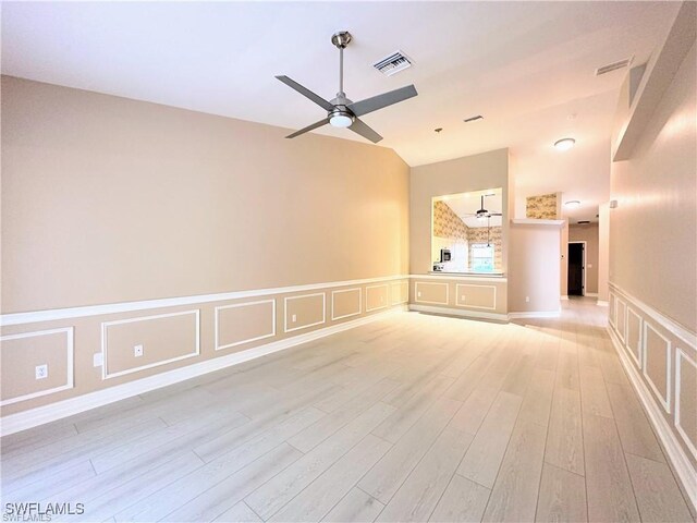 8088 Sanctuary Dr Unit 1, Naples, FL 34104 - unfurnished room with ceiling fan, light wood-style floors, vaulted ceiling, a decorative wall, and a wainscoted wall