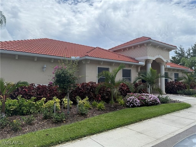 8088 Sanctuary Dr Unit 1, Naples, FL 34104 - view of front of house featuring stucco siding, a tile roof, and driveway