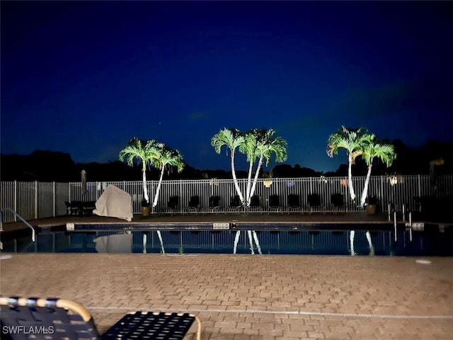 8088 Sanctuary Dr Unit 1, Naples, FL 34104 - pool at twilight featuring a community pool and a patio area