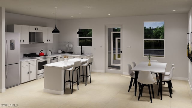 1075 Barnett St E, Lehigh Acres, FL 33974 - kitchen featuring freestanding refrigerator, gas range, a center island, a kitchen bar, and white cabinetry