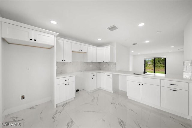 1032 Maxwell Ave S, Lehigh Acres, FL 33974 - kitchen featuring a sink, tasteful backsplash, recessed lighting, light marble finish flooring, and baseboards