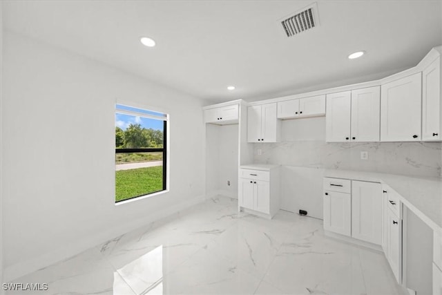 1032 Maxwell Ave S, Lehigh Acres, FL 33974 - kitchen with recessed lighting, light marble finish floors, white cabinets, and baseboards