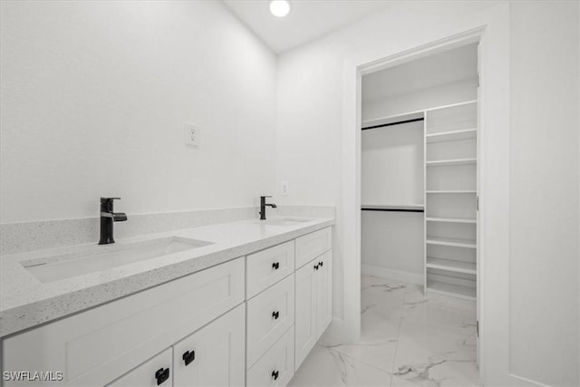 1032 Maxwell Ave S, Lehigh Acres, FL 33974 - bathroom featuring marble look tile flooring, double vanity, and a walk in closet