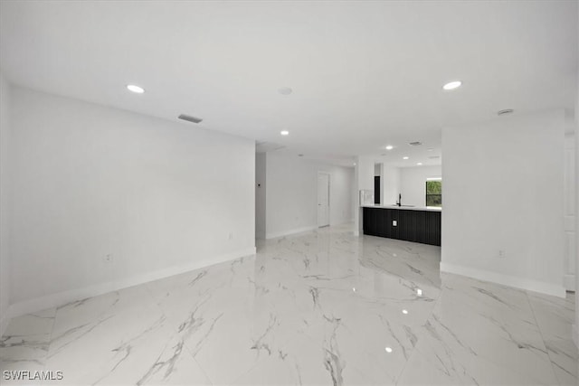 1032 Maxwell Ave S, Lehigh Acres, FL 33974 - unfurnished living room featuring recessed lighting, light marble finish flooring, baseboards, and a sink