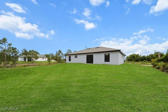 1032 Maxwell Ave S, Lehigh Acres, FL 33974 - back of property featuring a lawn and stucco siding