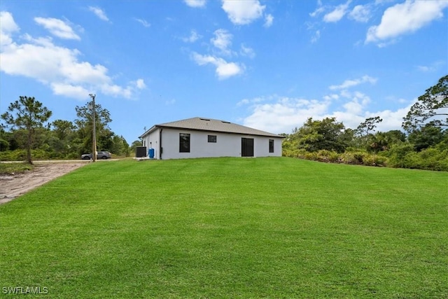 1032 Maxwell Ave S, Lehigh Acres, FL 33974 - back of house with a lawn, stucco siding, and driveway